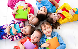 Kinder-liegen-im-Kreis-mit-Büchern