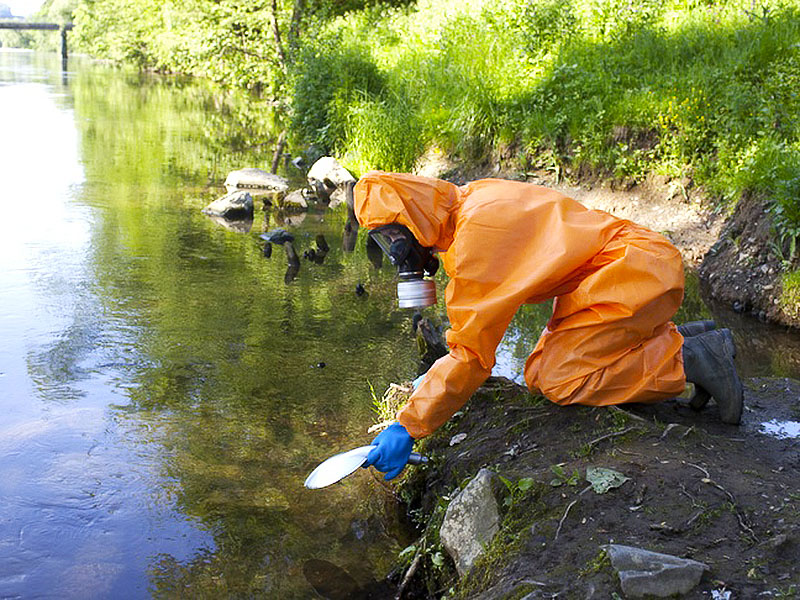 Laborant-untersucht-Bachwasser-in-Schutzanzug